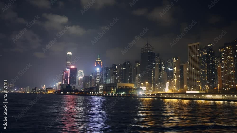 shot from a boat of a coastal city during the night, the city is very bright