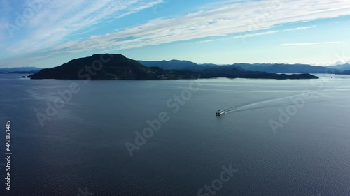 Electric ferry Ytterøyningen from Norled company distant aerial overview with beautiful coastline landscape in background - Ferry sailing towards Utbjoa Norway photo