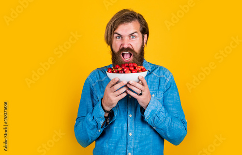 brutal bearded male man hold cherry berry  natural food