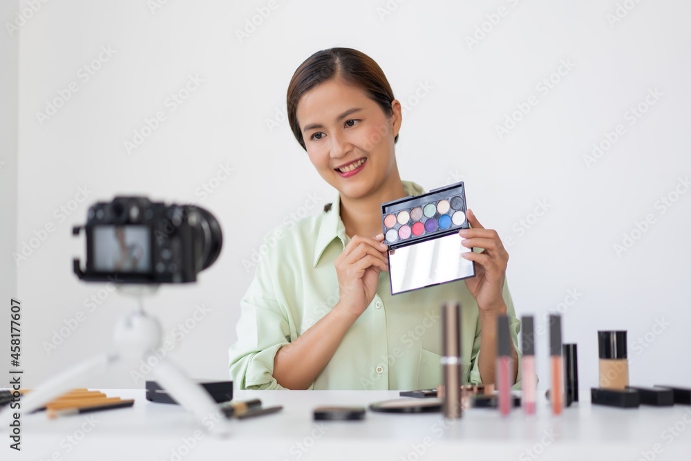A female beauty blogger reviewing quality of the colorful eyeshadow palette as a new arrival product A female beauty blogger reviewing quality of the colorful eyeshadow palette as a new arrival product