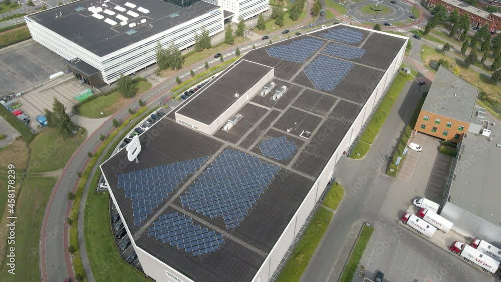 Jib down of warehouse with a lot of solar panels on rooftop Jib down of warehouse with a lot of solar panels on rooftop
