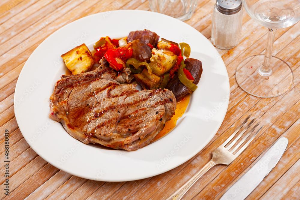 Appetizing grilled veal entrecote with side dish of sauteed vegetables..