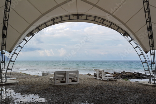 cafe tent on a deserted autumn beach against the background of the sea and clouds