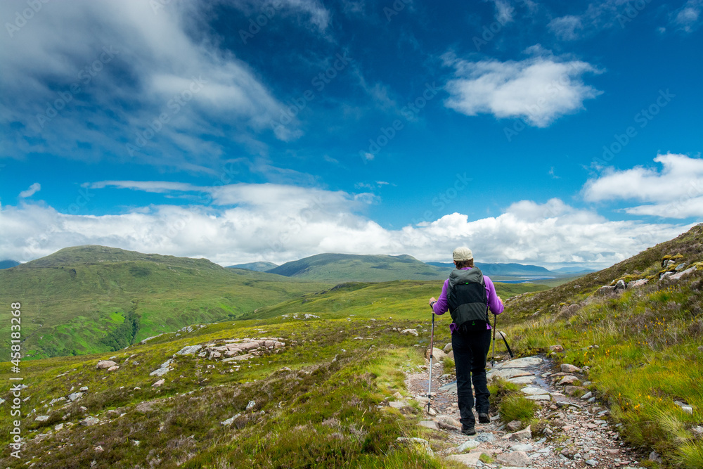Along the West Highland Way. A lonely hiker walks on the hiking path in the highland moor