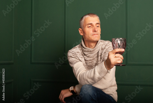 a man of age holds a bcal in his hands remembering the past years for the new year and Christmas photo