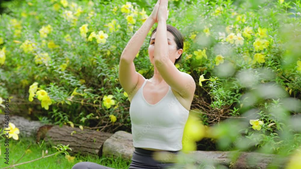 Young asian woman practicing yoga in garden.female happiness. blurred background.Healthy lifestyle and relaxation concept.Young girl doing yoga in the park. Young asian woman practicing yoga in garden.female happiness. blurred background.Healthy lifestyle and relaxation concept.Young girl doing yoga in the park.