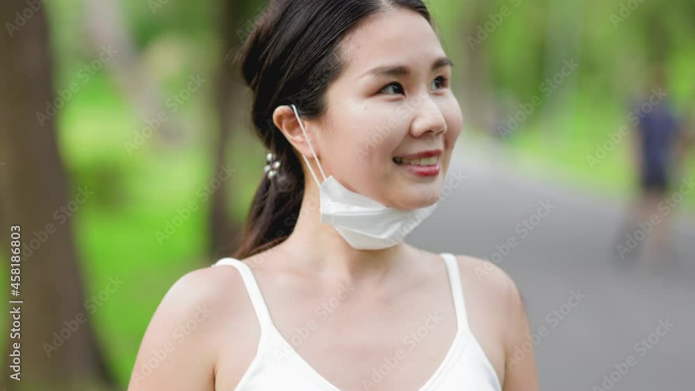 Asian runner jogging in the park during covid-19 pandemic. Working out in the days of the coronavirus.Fit woman jogging at outdoor .Healthy lifestyle concept. she have pois protective mask on face. Asian runner jogging in the park during covid-19 pandemic. Working out in the days of the coronavirus.Fit woman jogging at outdoor .Healthy lifestyle concept. she have pois protective mask on face.