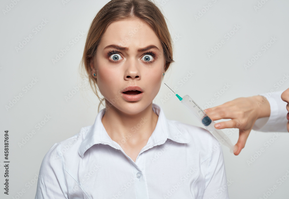 woman patient syringe in the hands of a doctor fear of injections phobia woman patient syringe in the hands of a doctor fear of injections phobia