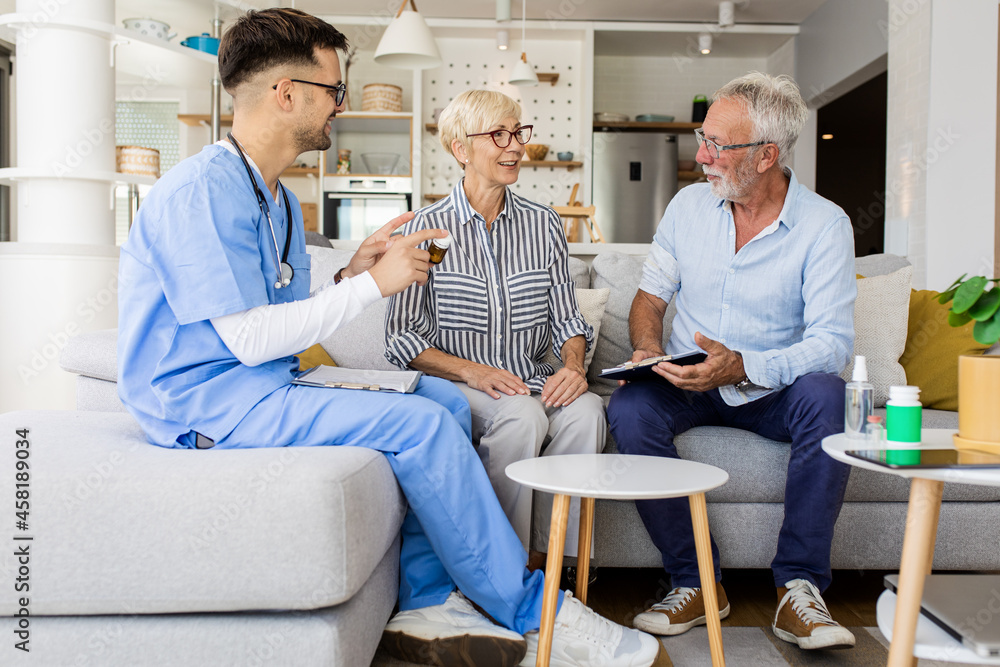 Male nurse talking to seniors patients while being in a home visit. Male nurse talking to seniors patients while being in a home visit.