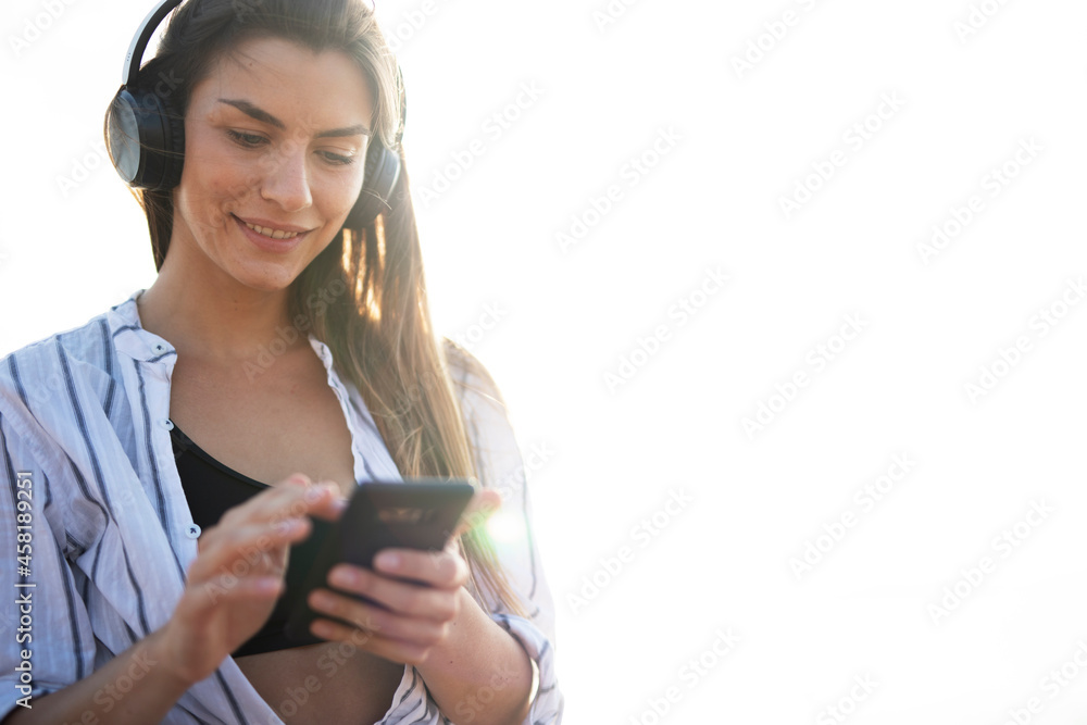 Happy young woman relaxing on the sandy beach. Beautiful woman listening the music.. Happy young woman relaxing on the sandy beach. Beautiful woman listening the music..