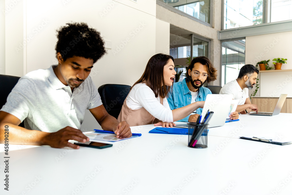 Multiracial group of coworkers working at conference room table preparing for business meeting. Copy space. Multiracial group of coworkers working at conference room table preparing for business meeting. Copy space.