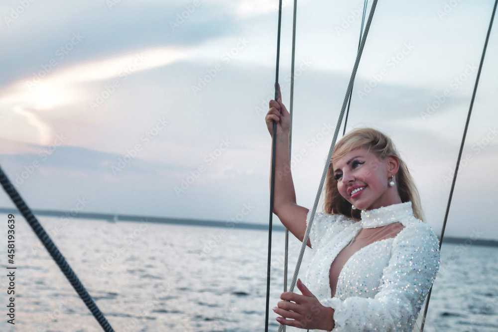 Joyful woman middle age portrait on deck of sailing yacht enjoying water trip
