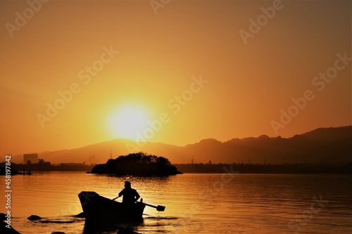 silhouette photography capturing boat and sunset