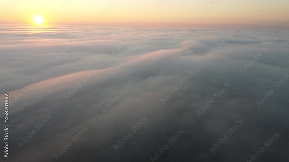 Morning sunrise over a thick autumn fog that covered the entire earth's surface.