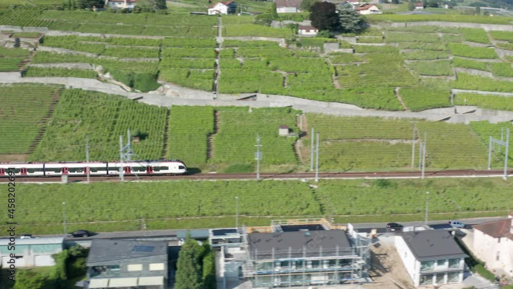 Aerial of train driving through beautiful Swiss landscape and panning towards a vast, beautiful lake Aerial of train driving through beautiful Swiss landscape and panning towards a vast, beautiful lake
