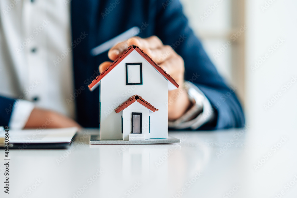 The real estate agent is explaining the house style to the clients who come to contact to see the house design and the purchase agreement. The real estate agent is explaining the house style to the clients who come to contact to see the house design and the purchase agreement.