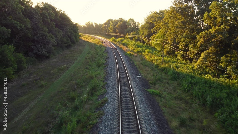 Railway traffic from the shade of trees to the morning sunlight.