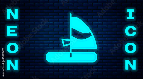 Glowing neon Windsurfing icon isolated on brick wall background. Vector