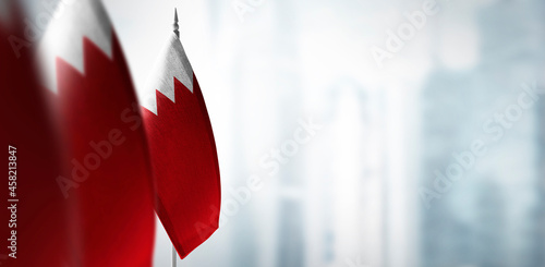 Small flags of Bahrain on a blurry background of the city