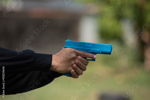 Police practice using blue rubber firearms in the lawn. 