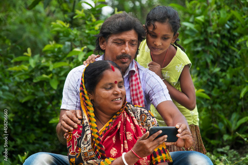 Photography 3 indian Rural Parents and daughter watching movie in agricultural field