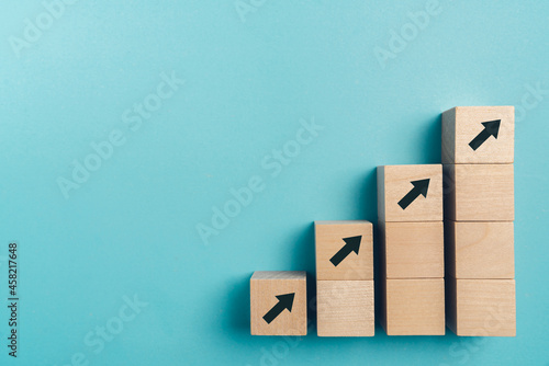 Business growth concept , wood block stacking as step stair on paper blue background, copy space.