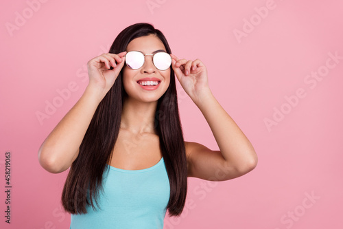 Photo of cool nice long hairdo lady look empty space wear spectacles blue top isolated on pastel pink color background
