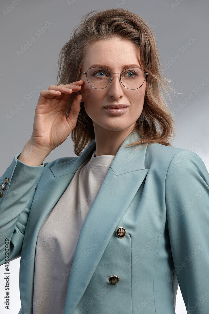 Portrait of nice adorable slim sweet lovely gorgeous attractive winsome cheerful clever smart intelligent wavy-haired lady touching glasses isolated over gray pastel background Portrait of nice adorable slim sweet lovely gorgeous attractive winsome cheerful clever smart intelligent wavy-haired lady touching glasses isolated over gray pastel background