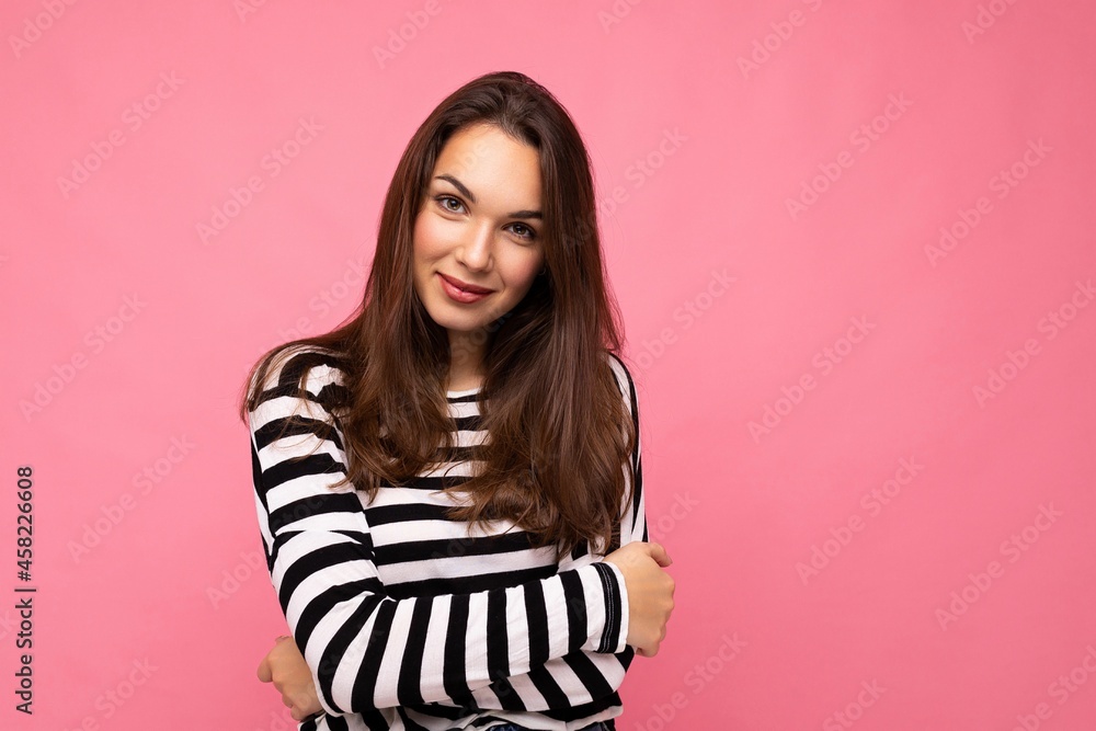 Photo portrait of young beautiful smiling hipster brunette woman in trendy pullover. Sexy carefree female person posing isolated near pink wall with empty space in studio. Positive model with natural Photo portrait of young beautiful smiling hipster brunette woman in trendy pullover. Sexy carefree female person posing isolated near pink wall with empty space in studio. Positive model with natural