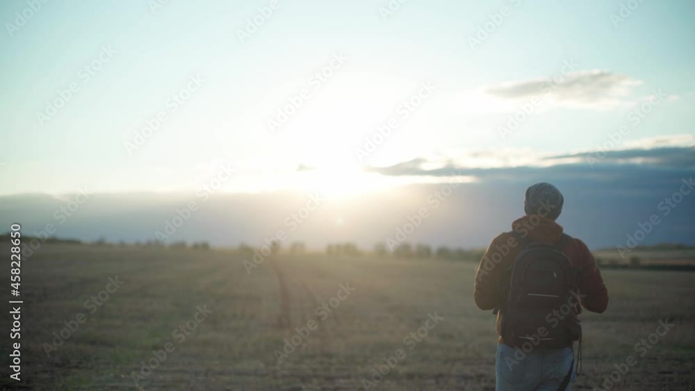 Man with a backpack in a field in autumn Man with a backpack in a field in autumn