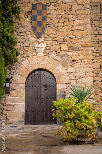 pintoresca puerta de madera en muro castillo de montsonis con escudo medieval