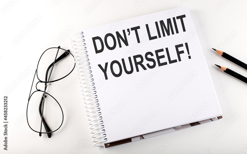 Notepad with text DON'T LIMIT YOURSELF . White background. Business concept Notepad with text DON'T LIMIT YOURSELF . White background. Business concept