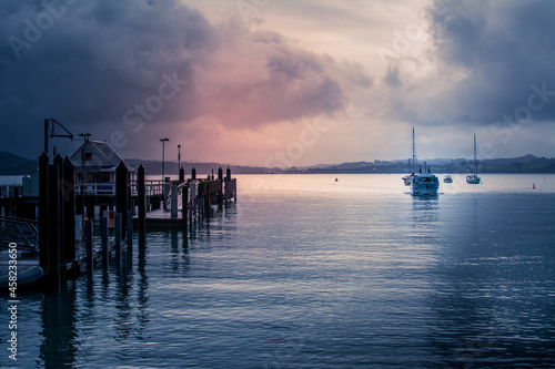 Retro style photo of a small ferry appoaching Russel Wharf on a stormy evening. photo