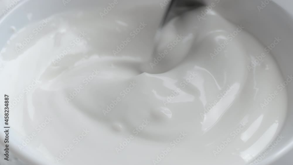 Shooting of bowl with stirred cream and spoon Shooting of bowl with stirred cream and spoon