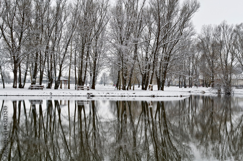 Small fishing house on the snowy lake side at winter. Ózd, Hungary. photo