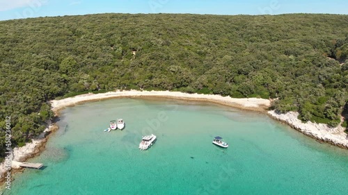 Drone footage of Kampor on Rab Island in Croatia. Epic landscape, blue sea and green island with small boats.. Summer day and blue sky. photo