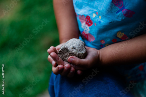 Kamień trzymany w rękach przez dziewczynkę