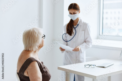 old woman patient on examination by a nurse medical office © SHOTPRIME STUDIO
