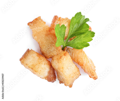 Tasty fried cracklings with parsley on white background, top view. Cooked pork lard