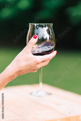 Woman holding a glass with red wine in her hand