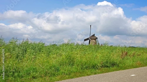Traditional ancient windmills in the Dutch countryside. Outdoor tours and family bike tours in the Dutch countryside among the windmills. Netherlands typical landscape, tradional attraction park photo