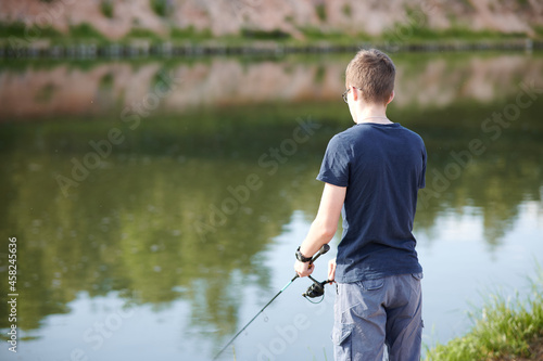 Young guy fishing on Lake with rod . Travel Lifestyle concept summer vacations.