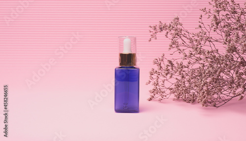 blue glass bottle with a dropper for cosmetics on a pink background. Packaging for gel, serum, advertising and promotion. Natural organic products