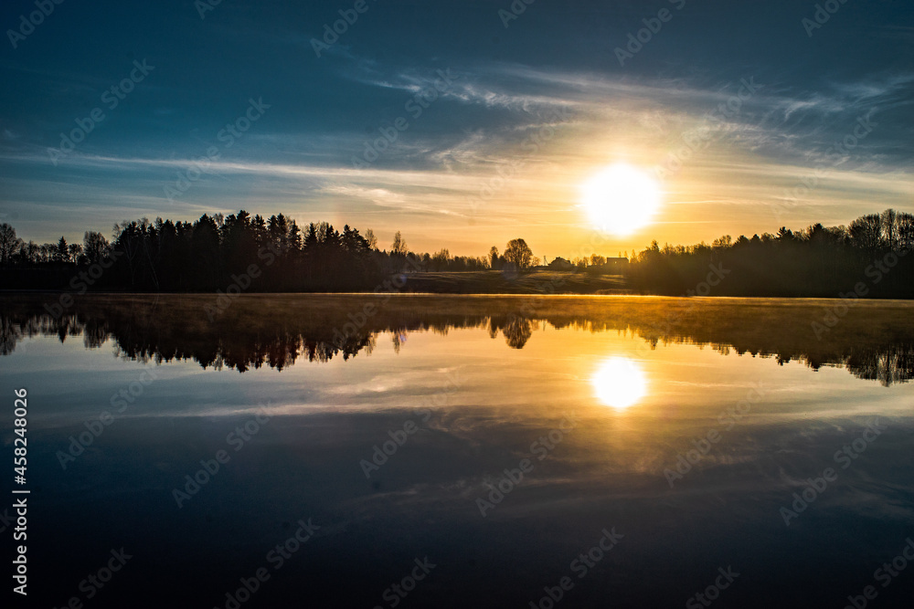 Sunrise over the river with a beautiful mirror-like reflection