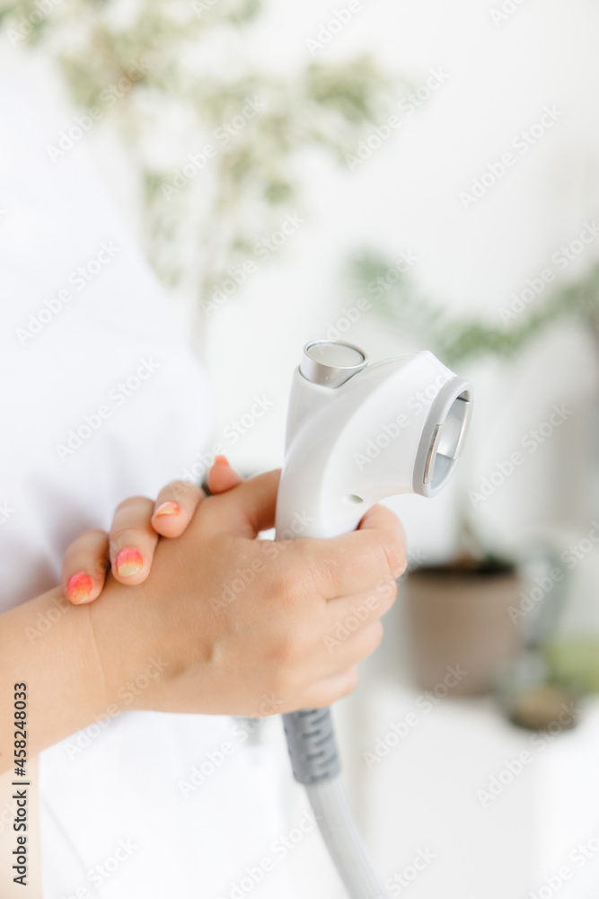 The handle of the massage device. body and face massage. beauty salon. Manipulator for lpg massage on the hands of a cosmetologist. Close-up view.