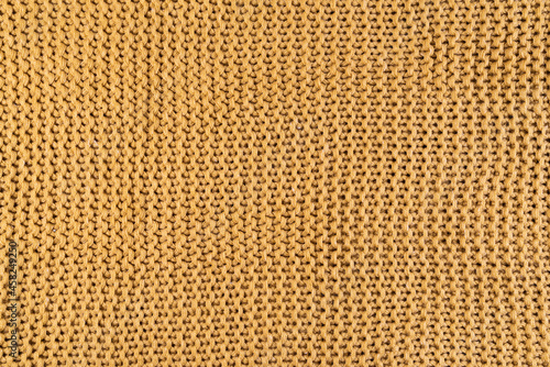close-up of gold colored knitted fabric, textile background