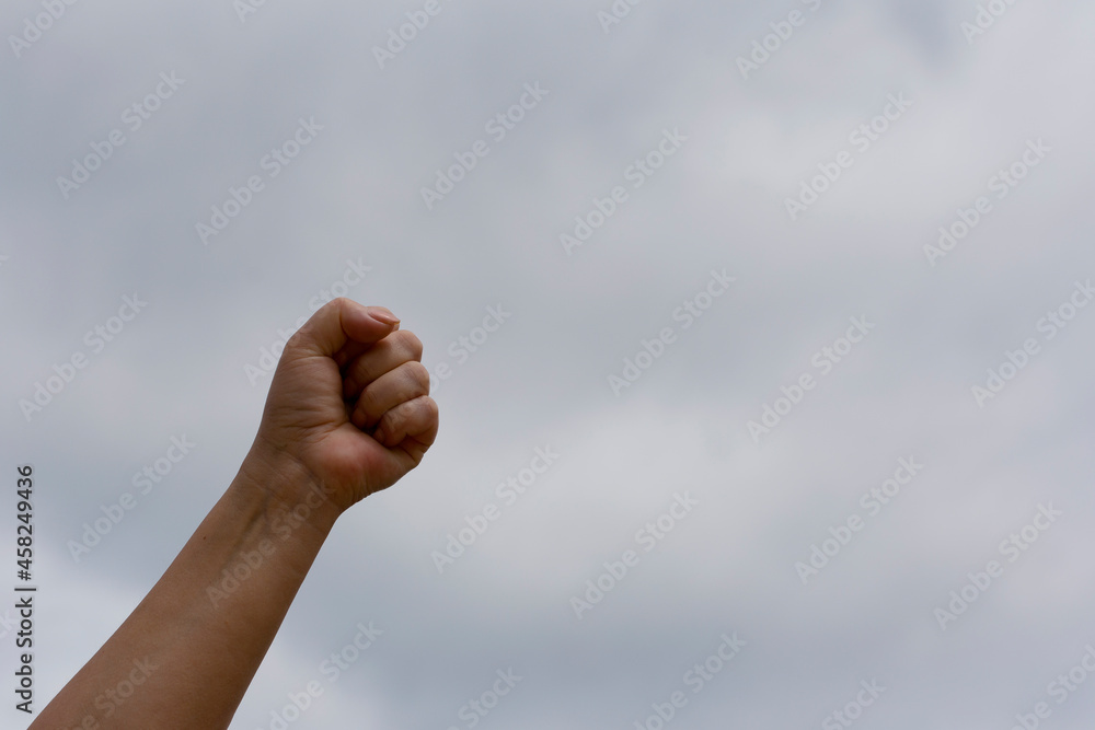 Clenched fist up against the sky. Struggle and leadership concept Clenched fist up against the sky. Struggle and leadership concept