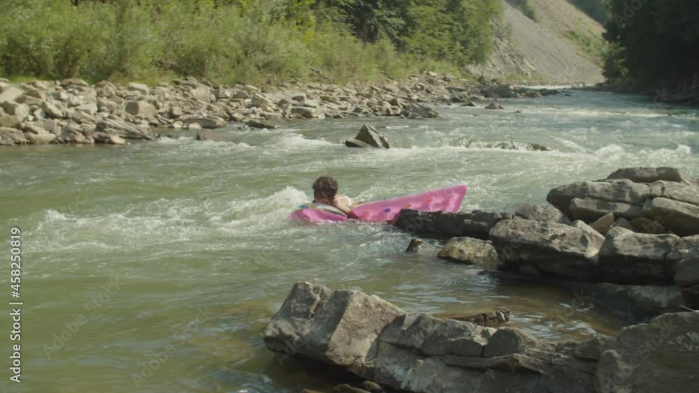 Carefree lovely black woman in bikini enjoying leisure and freedom, floating down on inflatable mattress on rough mountain river flow, expressing cheerful mood and happiness during summer vacations Carefree lovely black woman in bikini enjoying leisure and freedom, floating down on inflatable mattress on rough mountain river flow, expressing cheerful mood and happiness during summer vacations