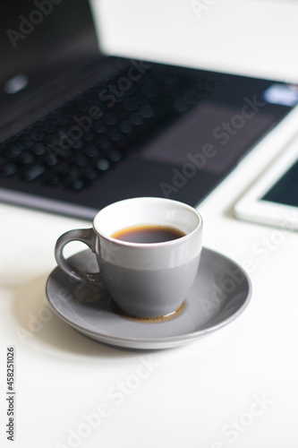 Taza de café con ordenador portátil.