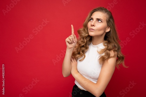 Photo of cute nice winsome angry dissatisfied adult woman wearing casual outfit isolated on background wall with copy space pointing at free space with hands